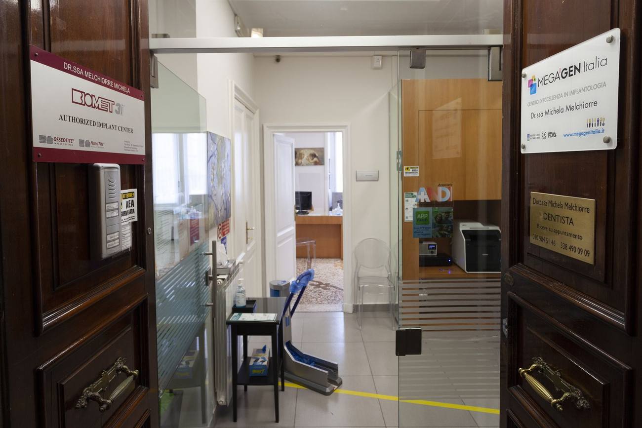 L'ingresso dello studio, con la porta a vetri e il portoncino scuro